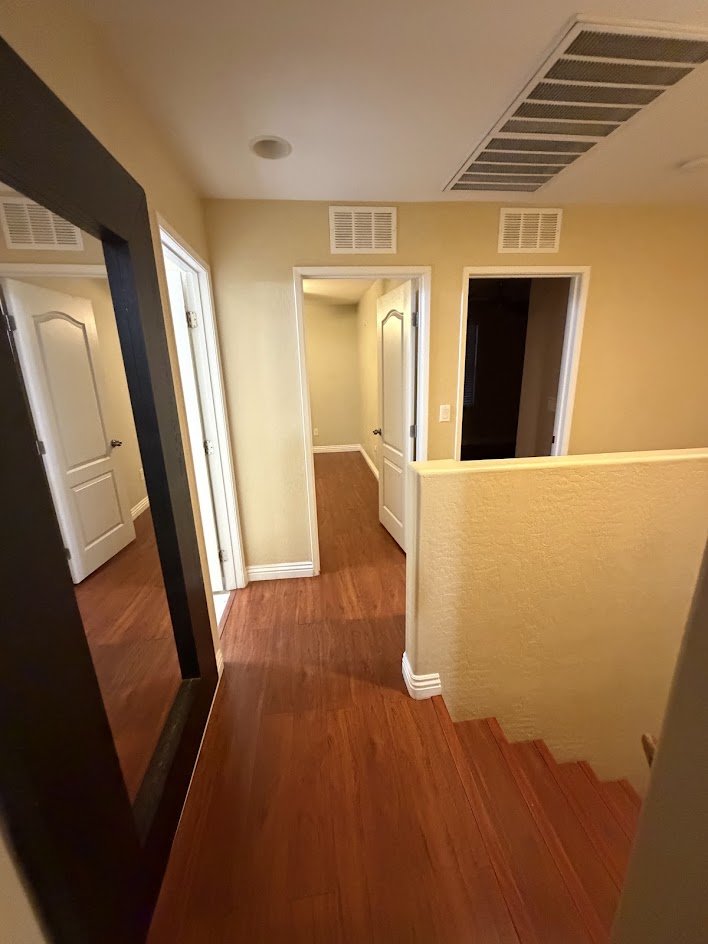 A clean upstairs hallway with shining wood floors