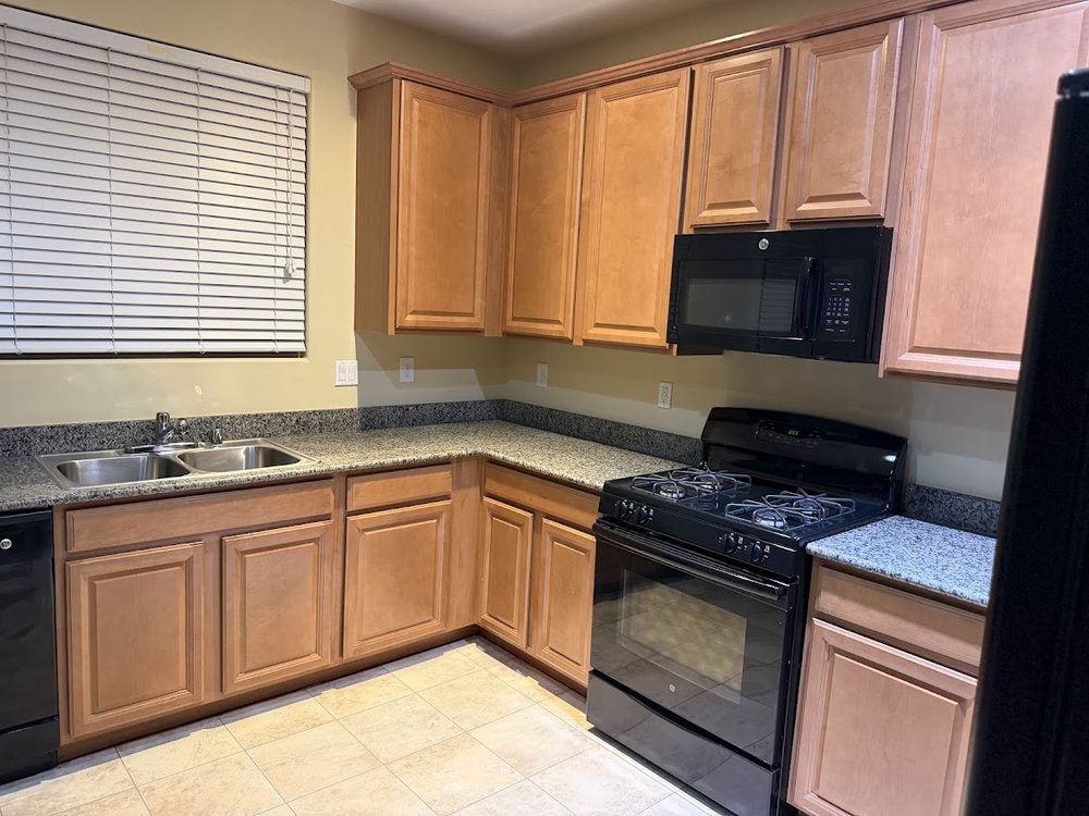 A clean kitchen with wiped cabinets, counters and stove