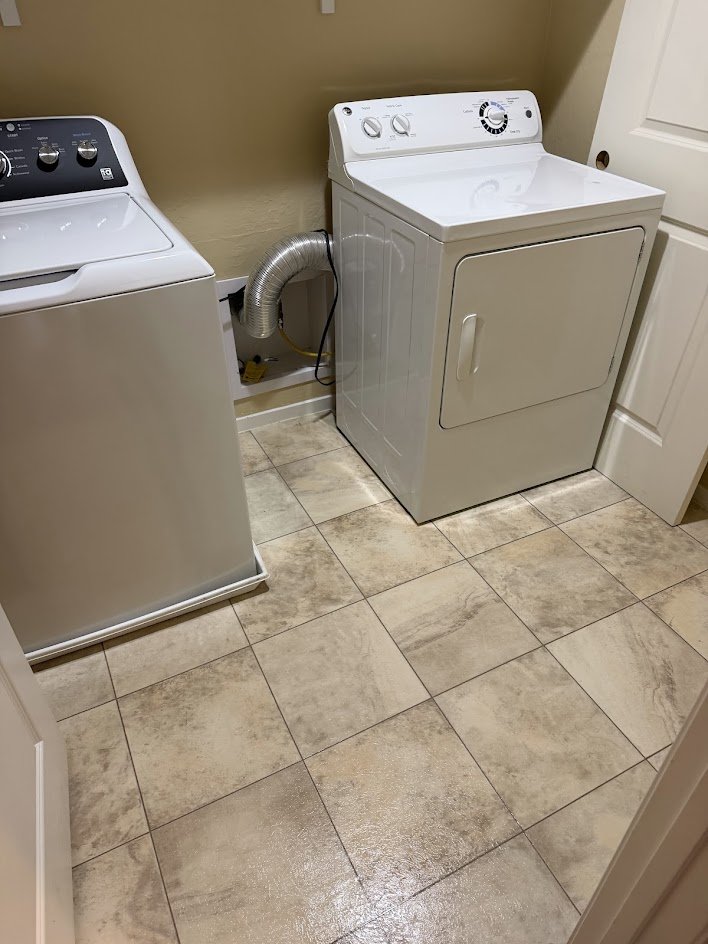 A clean laundry room with mopped tile floors