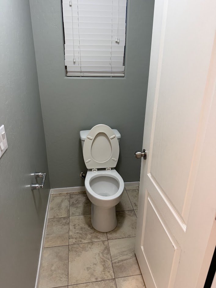 A clean toilet room with fresh, mopped floors